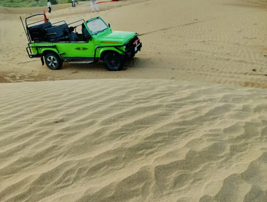 Open-top 4x4 safari jeep parked on golden sand dunes in Osian