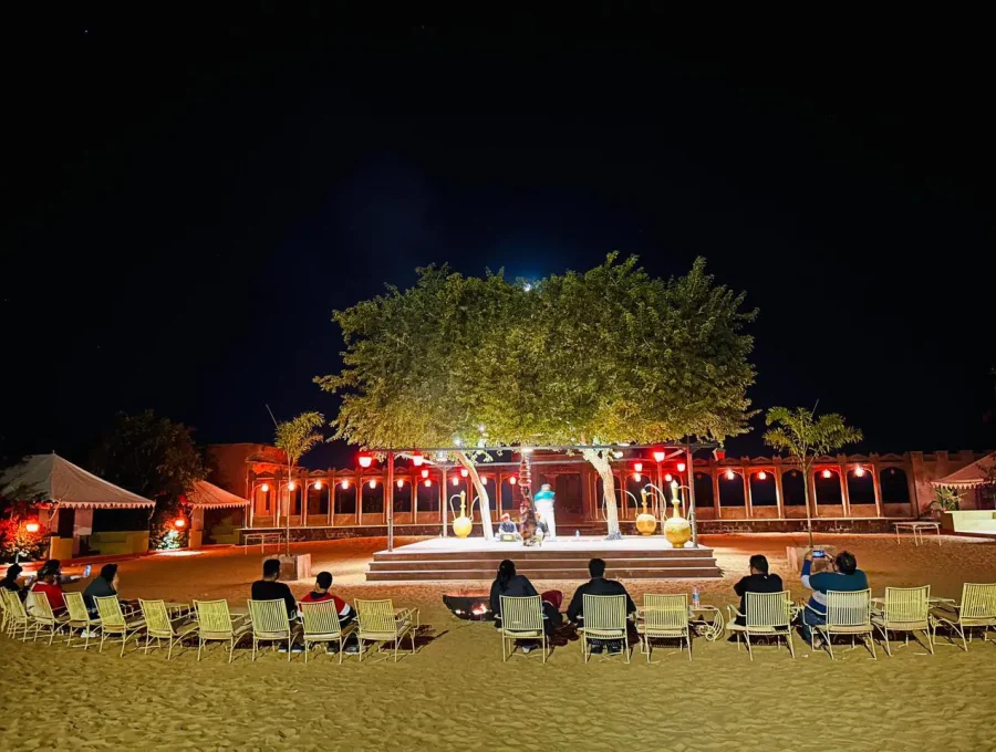 Authentic Rajasthani dinner tables illuminated with lanterns under the starlit night sky in Osian